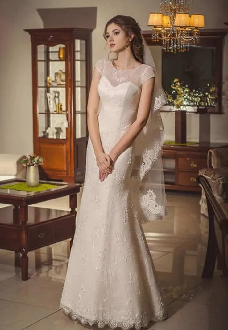 ---Elegant ivory wedding dress for a romantic woman made of lace with illusions in the decollette and short sleeves--